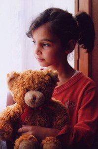 A seven-year-old finds security with her Teddy bear at Zadig Orphanage.