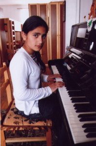 Playing piano offers a sense of enjoyment for this young girl at Zadig Orphanage.